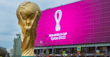 A replica of the World Cup trophy is backdropped by the pink logo of FIFA World Cup 2022, Sep. 4, 2019, Moscow, Russia. (Shutterstock Photo)