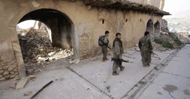 PKK terrorists walk in the damaged streets of Sinjar, Iraq, Jan. 29, 2015. (AP File Photo)