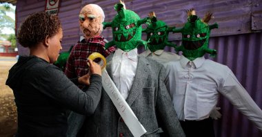A woman tapes the word "omicron" to a handmade doll depicting the COVID-19 omicron variant in Managua, Nicaragua, Dec. 27, 2021. (AFP Photo)