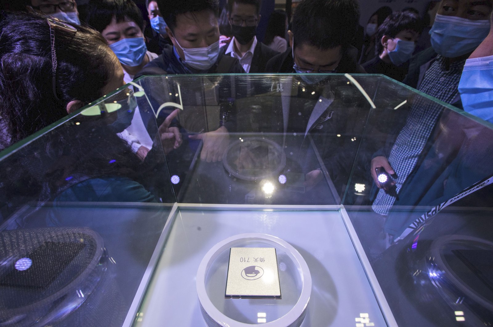 Visitors wearing masks look at the ARM-structure server processor Yitian 710, developed by Alibaba&#039;s in-house semiconductor unit T-Head, at the Apsara Conference, an annual cloud service technology forum hosted by Alibaba Group, in Hangzhou, Zhejiang province, east China, Oct. 19, 2021. (AP Photo)