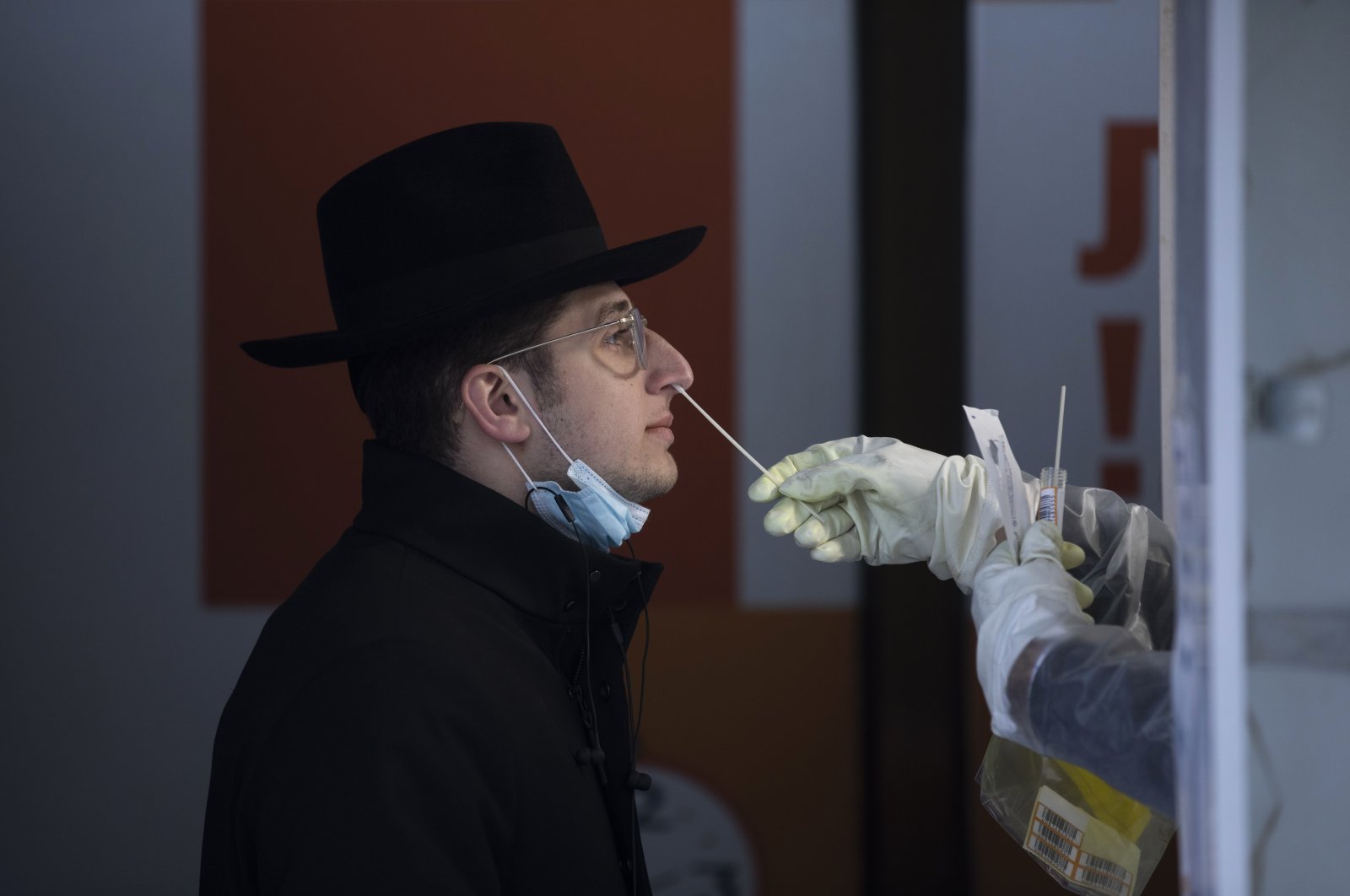 An Israeli health worker tests an unvaccinated ultra-Orthodox Jewish seminary student for COVID-19 at a coronavirus testing center in West Jerusalem, Israel, Dec. 22, 2021. (AP Photo)