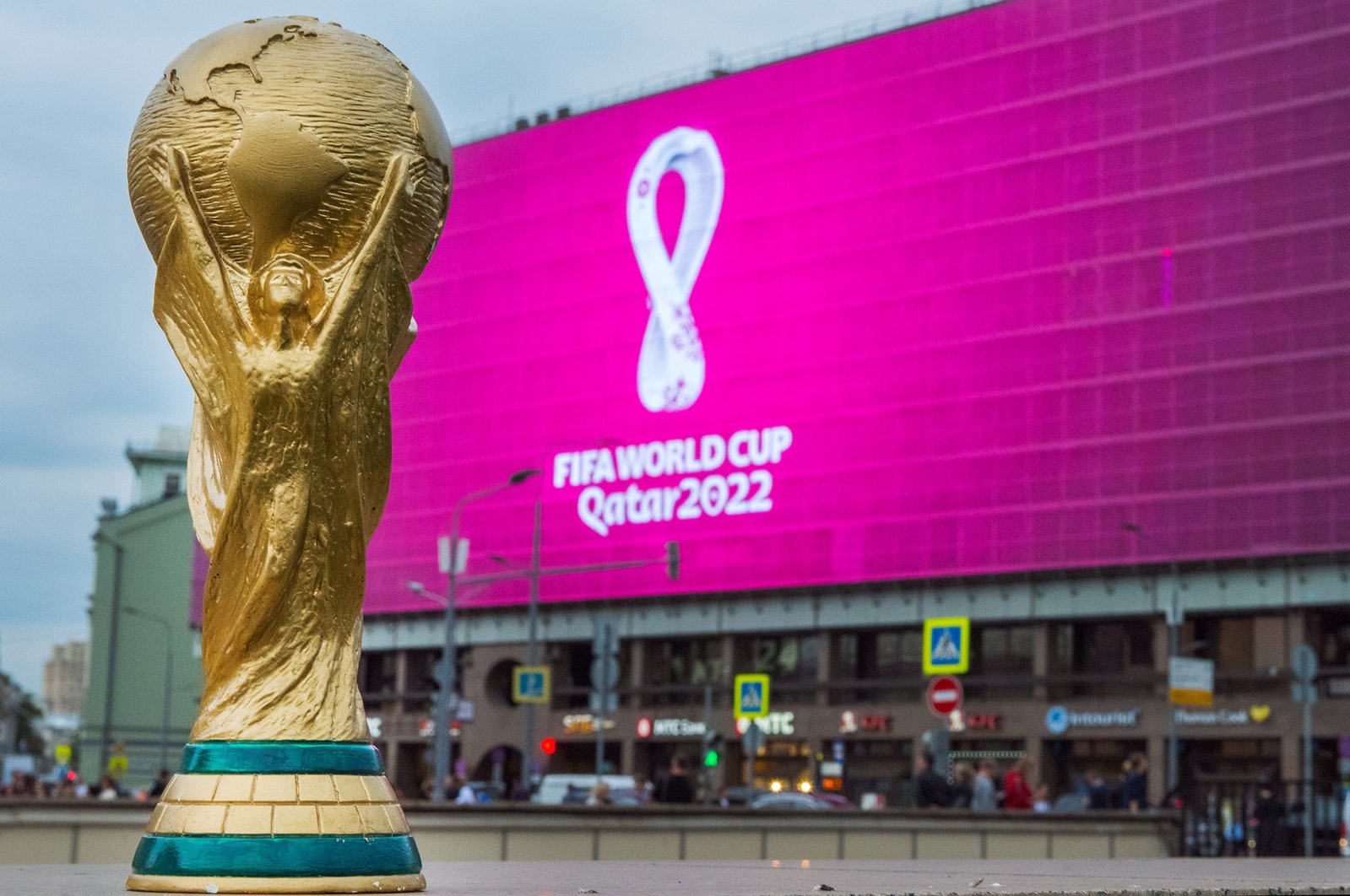 A replica of the World Cup trophy is backdropped by the pink logo of FIFA World Cup 2022, Sep. 4, 2019, Moscow, Russia. (Shutterstock Photo)