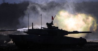 Japanese military Type 90 tanks fire at a target with live ammunition during an annual drill at Minami Eniwa Camp in Eniwa on the northern Japanese island of Hokkaido, Dec. 6, 2021. (AP Photo)