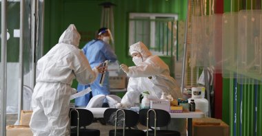 Medical workers wearing protective gear prepare to take samples at a temporary screening clinic for the coronavirus in Seoul, South Korea, Dec. 29, 2021. (AP Photo)