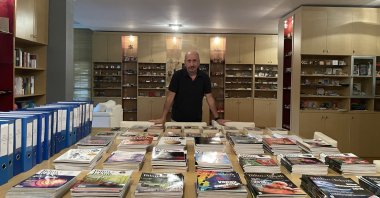 Emrehan Halıcı poses with magazines in which his columns have been published in the capital Ankara, Turkey, Dec. 29, 2021. (AA PHOTO)