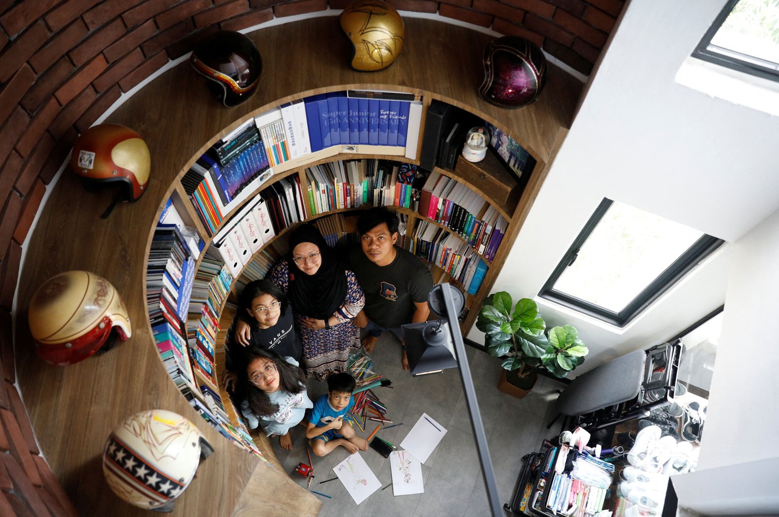 Kamal, 40, and Sri, 40, pose with their children Ayumi, 14, Tiara, 13, and Kazril, 7, at a home library area inspired by Harry Potter movies, in their 37-year-old executive maisonette public housing apartment in Singapore, May 3, 2021. (Reuters Photo)