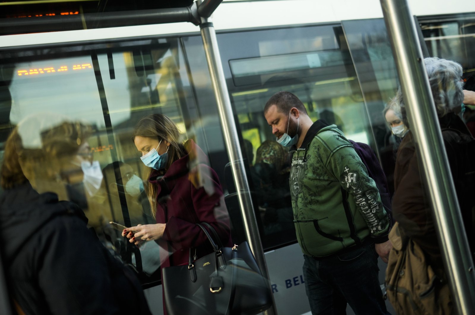 Commuters, wearing protective face masks to prevent the spread of COVID-19, disembark a streetcar in Istanbul, Turkey, Dec. 27, 2021. (AP PHOTO)