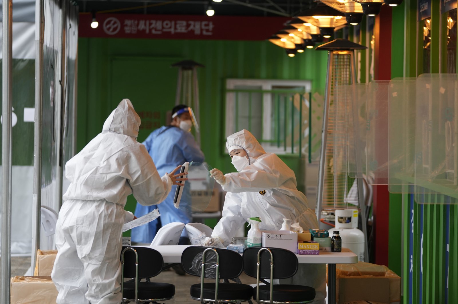 Medical workers wearing protective gear prepare to take samples at a temporary screening clinic for the coronavirus in Seoul, South Korea, Dec. 29, 2021. (AP Photo)