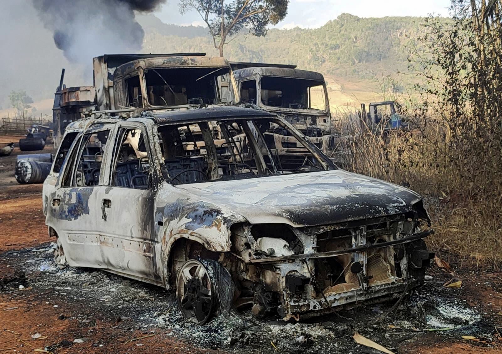 In this photo provided by the Karenni Nationalities Defense Force (KNDF), vehicles smolder in Hpruso township, Kayah state, Myanmar, Friday, Dec. 24, 2021. (AP Photo)