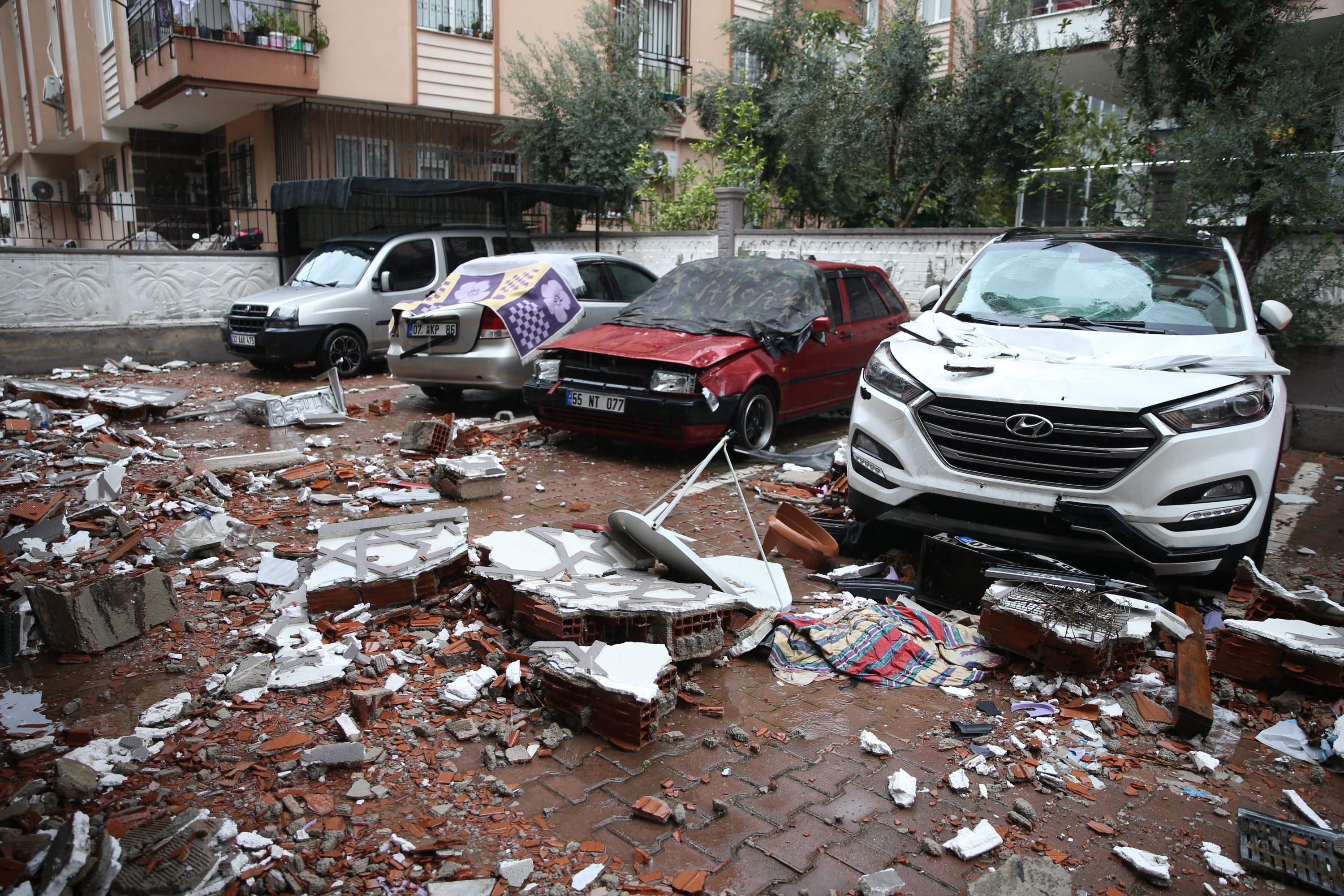Mobil yang rusak terlihat setelah tertimpa benda jatuh dari atap di distrik Kepez di Antalya, Turki selatan, 30 Desember 2021. (AA Photo)