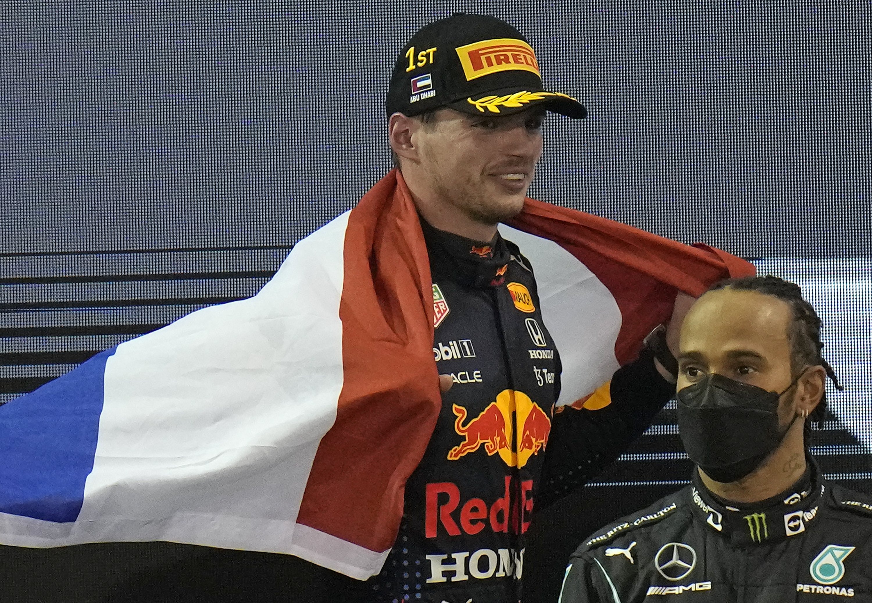 Pembalap Red Bull Max Verstappen (kiri) merayakan menjadi juara dunia setelah memenangkan F1 Grand Prix Abu Dhabi, Abu Dhabi, UEA, 12 Desember 2021. (AP Photo)