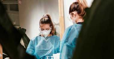 A registered nurse (RN) is seen reflected in the mirror before administering a nasal swab test for the coronavirus at a Sameday Health clinic in the Brentwood neighborhood of Los Angeles, California, U.S., Dec. 27, 2021. (Reuters Photo)