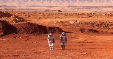 A couple of astronauts from a team from Europe and Israel walk in spacesuits during a training mission that simulates the conditions on Mars, at an off-site station in the Ramon Crater in Mitzpe Ramon in Israel&#039;s southern Negev desert, Oct. 10, 2021. (AFP Photo)
