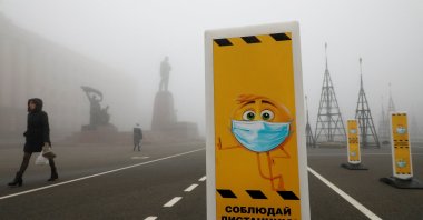 Pedestrians walk near a skating rink past signs requesting to wear protective face masks and maintain social distance amid the coronavirus disease outbreak in Stavropol, Russia, Dec. 1, 2020. (REUTERS Photo)