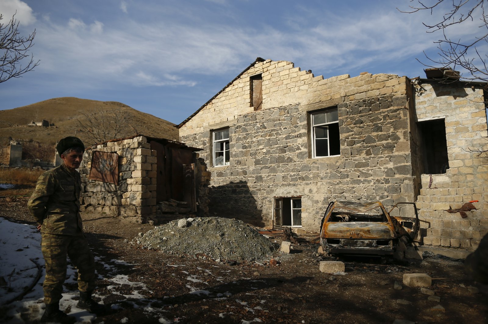 An Azerbaijani soldier stands near a destroyed house after the transfer of the Kalbajar region to Azerbaijani control, as part of a peace deal requiring Armenia to cede Azerbaijani territories they illegally occupied outside Nagorno-Karabakh, Kalbajar, Azerbaijan, Dec. 2, 2020. (AP File Photo)