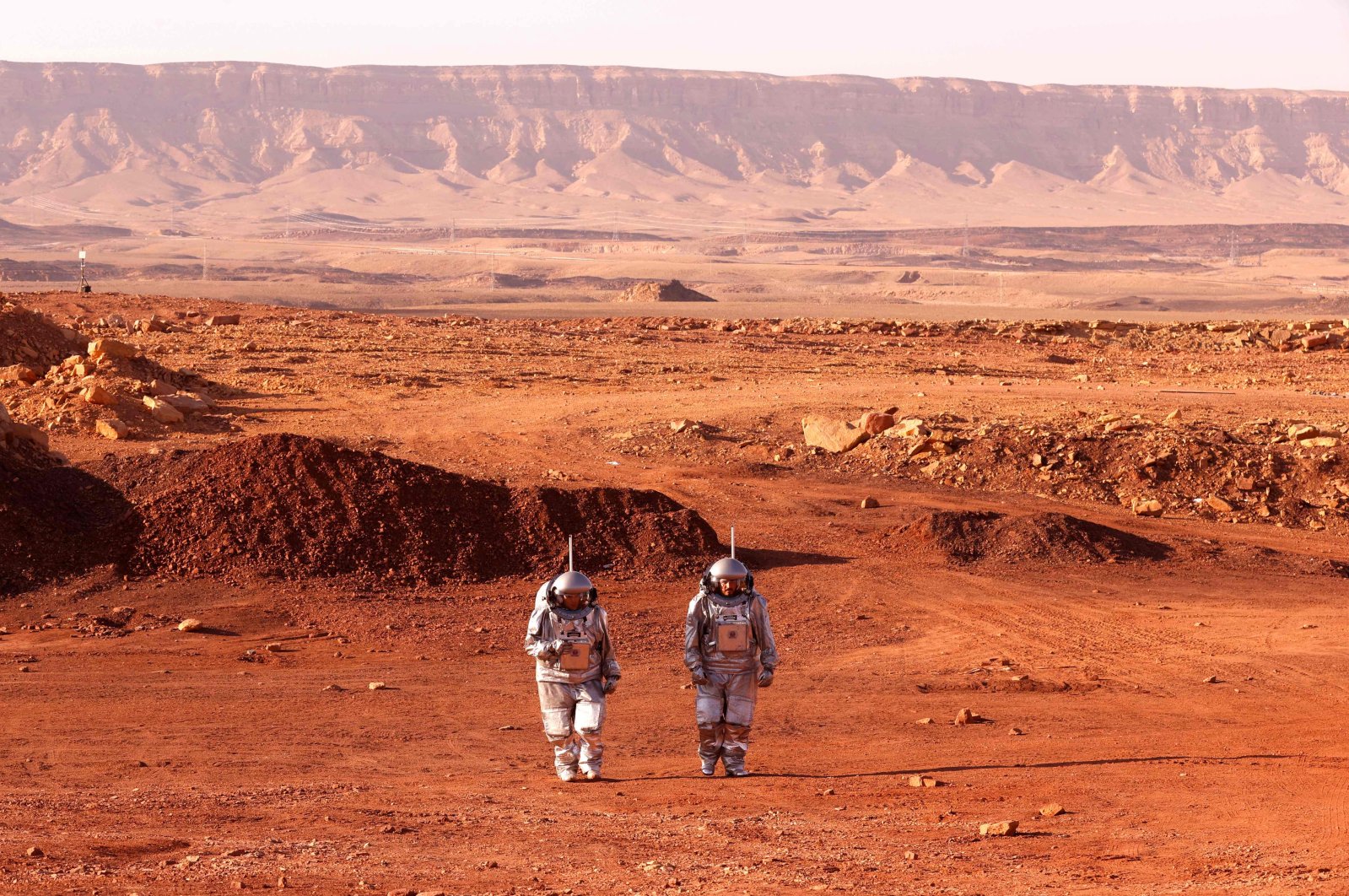 A couple of astronauts from a team from Europe and Israel walk in spacesuits during a training mission that simulates the conditions on Mars, at an off-site station in the Ramon Crater in Mitzpe Ramon in Israel&#039;s southern Negev desert, Oct. 10, 2021. (AFP Photo)