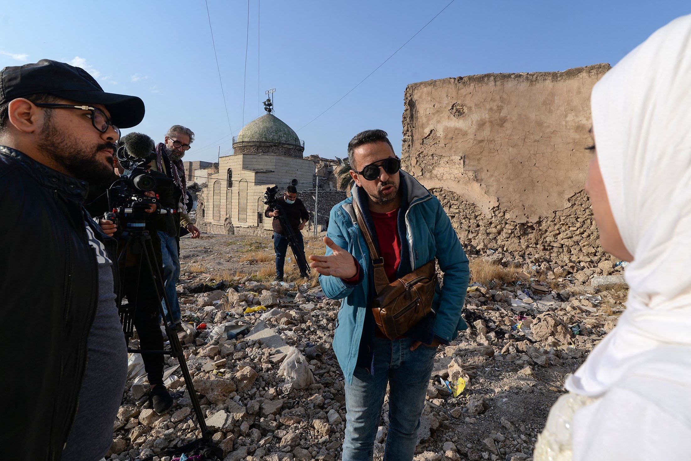 Siswa sekolah film mengerjakan adegan dengan aktor berpakaian pengantin, di kota utara Mosul yang dilanda perang, Irak, 15 Desember 2021. (AFP Photo)