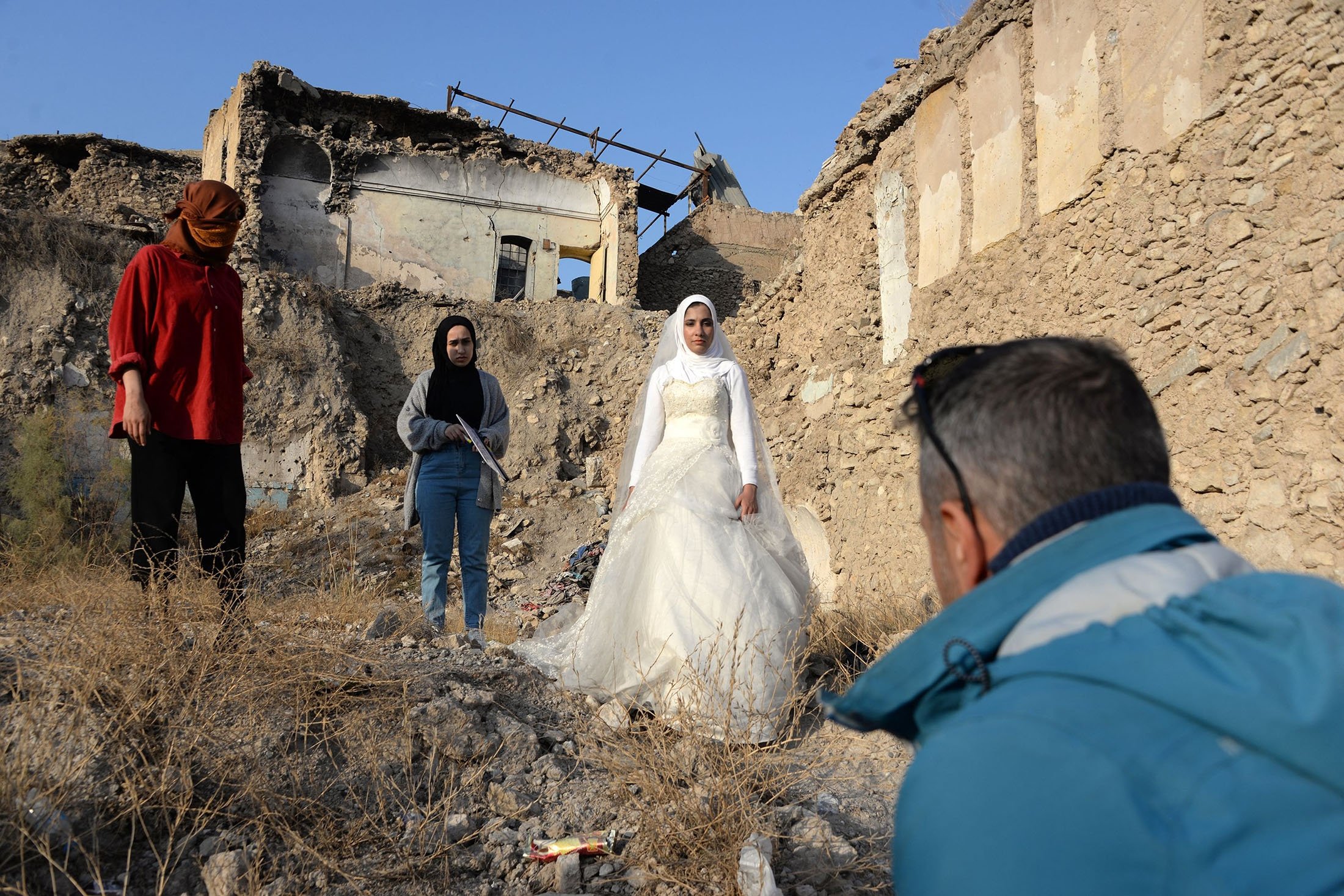 Siswa sekolah film mengerjakan adegan dengan aktor berpakaian pengantin, di kota utara Mosul yang dilanda perang, Irak, 15 Desember 2021. (AFP Photo)