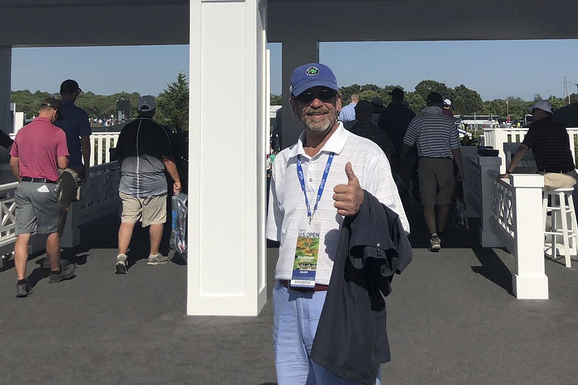 Tom Randele, yang nama aslinya menurut pihak berwenang adalah Ted Conrad, berdiri di depan sebuah foto di pintu masuk Turnamen Golf AS Terbuka 2018 di Klub Golf Shinnecock Hills, di Southampton, New York, AS (Bob Van Wert via AP)