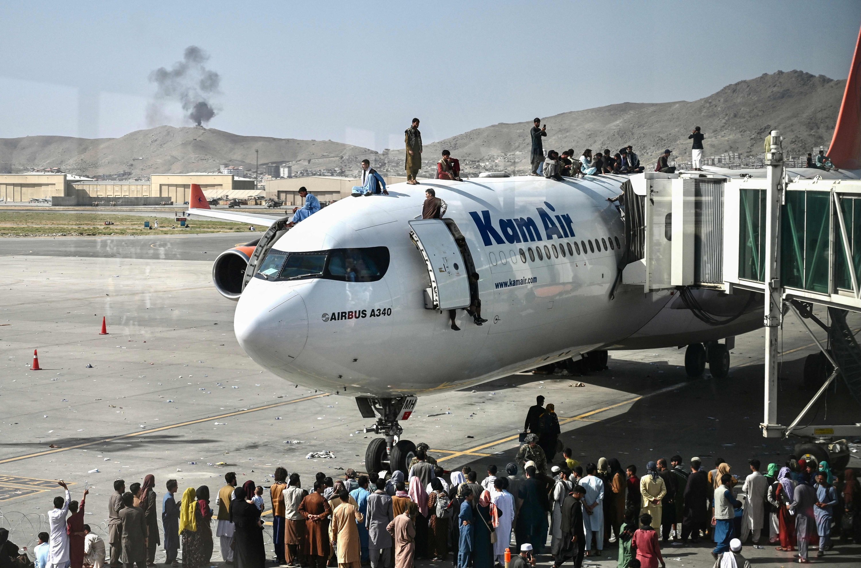 Orang-orang Afghanistan naik ke atas pesawat saat mereka menunggu di bandara Kabul di Kabul, Afghanistan, 16 Agustus 2021. (AFP Photo)