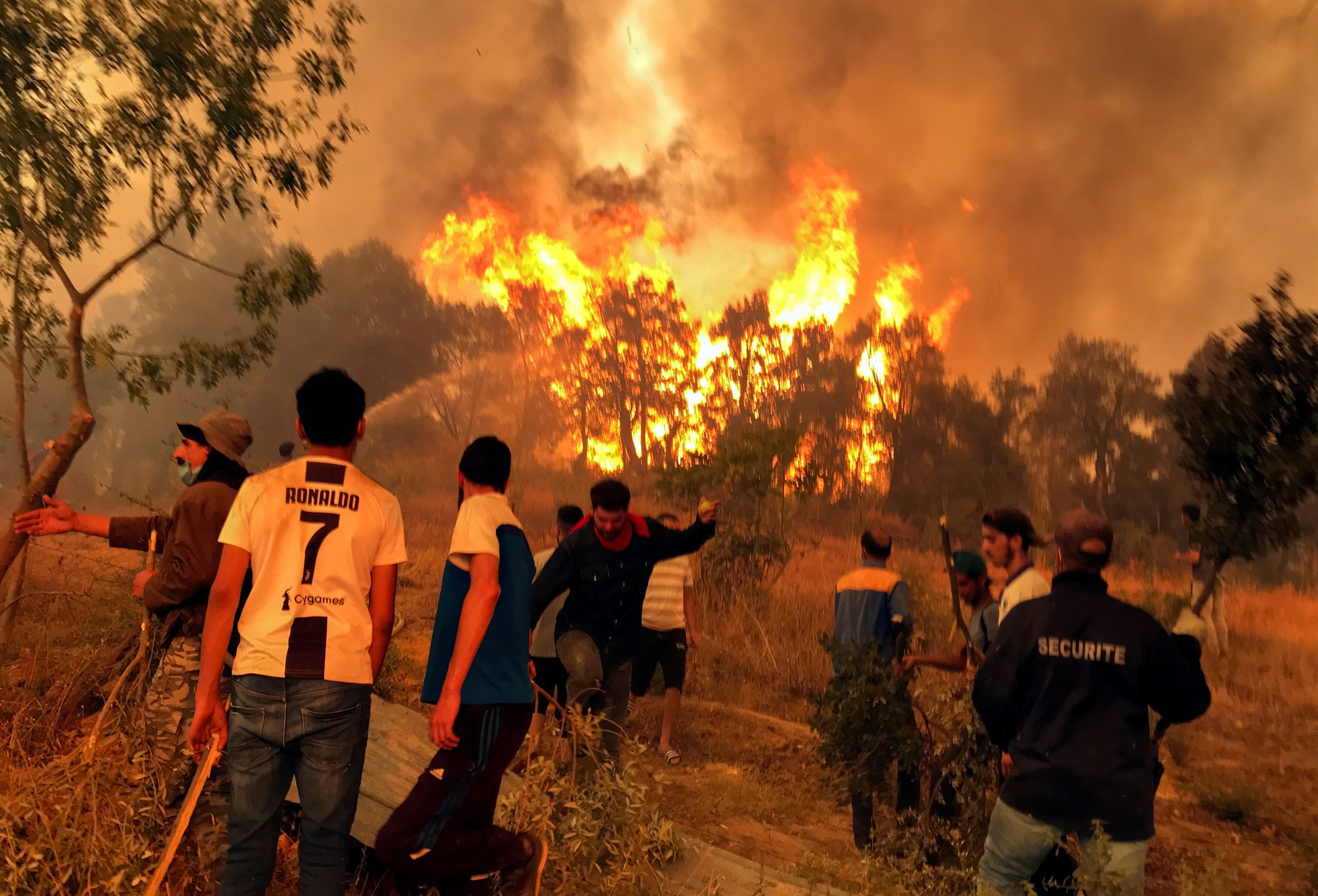 Penduduk desa berusaha memadamkan api di desa Achallam di wilayah pegunungan Kabylie di Tizi Ouzou, timur Aljir, Aljazair, 11 Agustus 2021. (Foto Reuters)