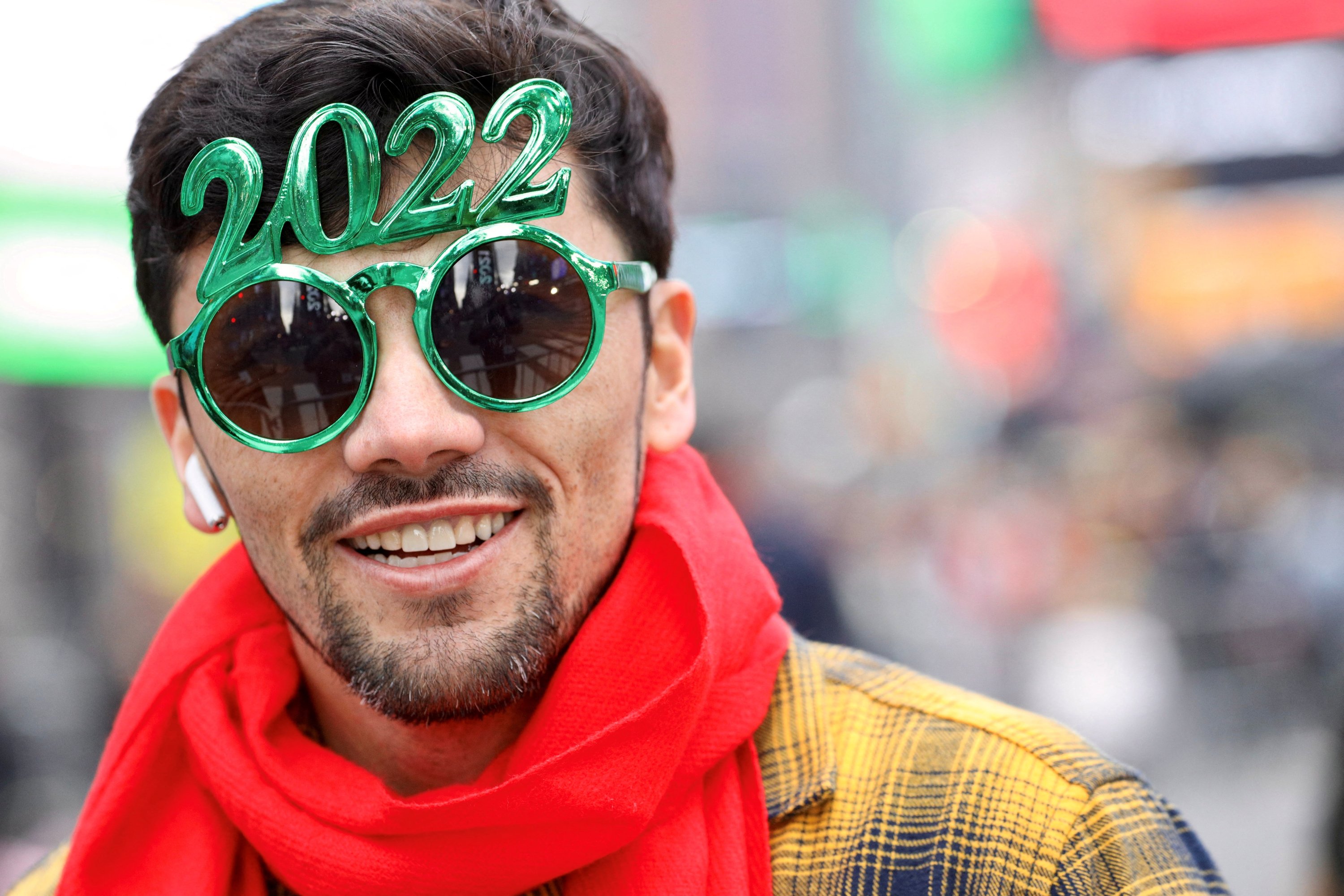 Seseorang yang memakai kacamata 2022 melihat jelang perayaan Malam Tahun Baru di Times Square, New York City, AS, 31 Desember 2021. (Foto Reuters)