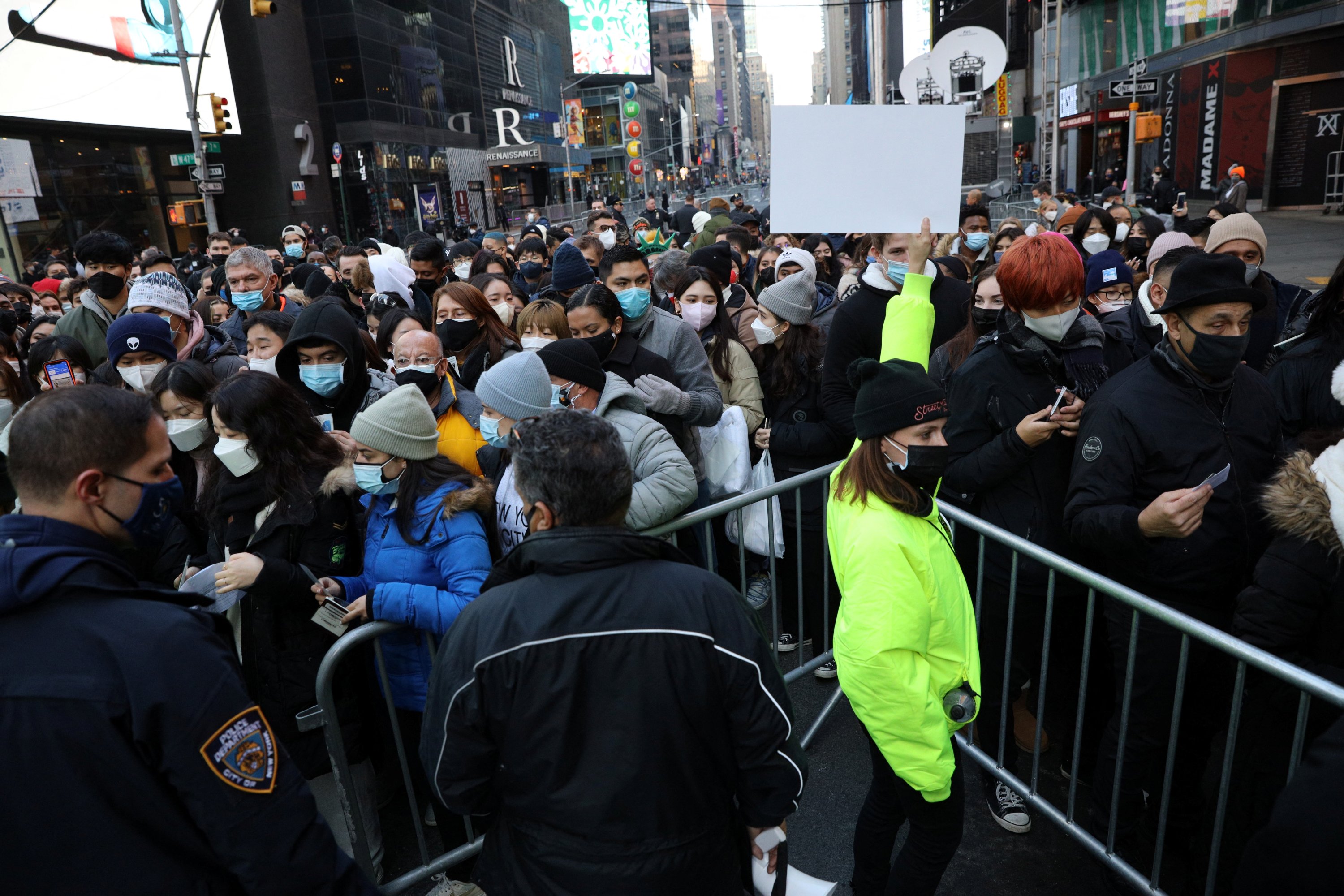 Orang-orang berkumpul di pintu masuk keamanan di Times Square menjelang perayaan Malam Tahun Baru, New York City, AS, 31 Desember 2021. (Foto Reuters)