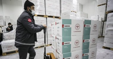 A worker carries boxes of Turkovac, Turkey's first locally made COVID-19 vaccine at a warehouse in the capital Ankara, Turkey, Dec. 27, 2021. (AA PHOTO)