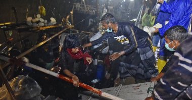 Rohingya men help others climb off their boat upon arrival at Krueng Geukueh Port in North Aceh, Indonesia, Dec. 31, 2021. (AP Photo)