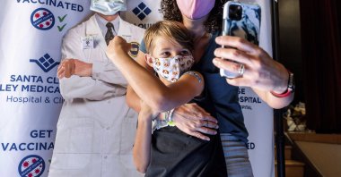 Finn Washburn, 9, shows his vaccination site as his mother, Kate Elsley, takes a photo shortly after he received a Pfizer COVID-19 vaccine in San Jose, California, U.S., on Nov. 3, 2021. (AP Photo)