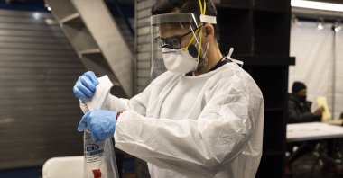 A medical worker puts used nasal swabs into a bag at a COVID-19 testing site in Times Square subway station in New York, U.S., Dec. 30, 2021. (AP Photo)