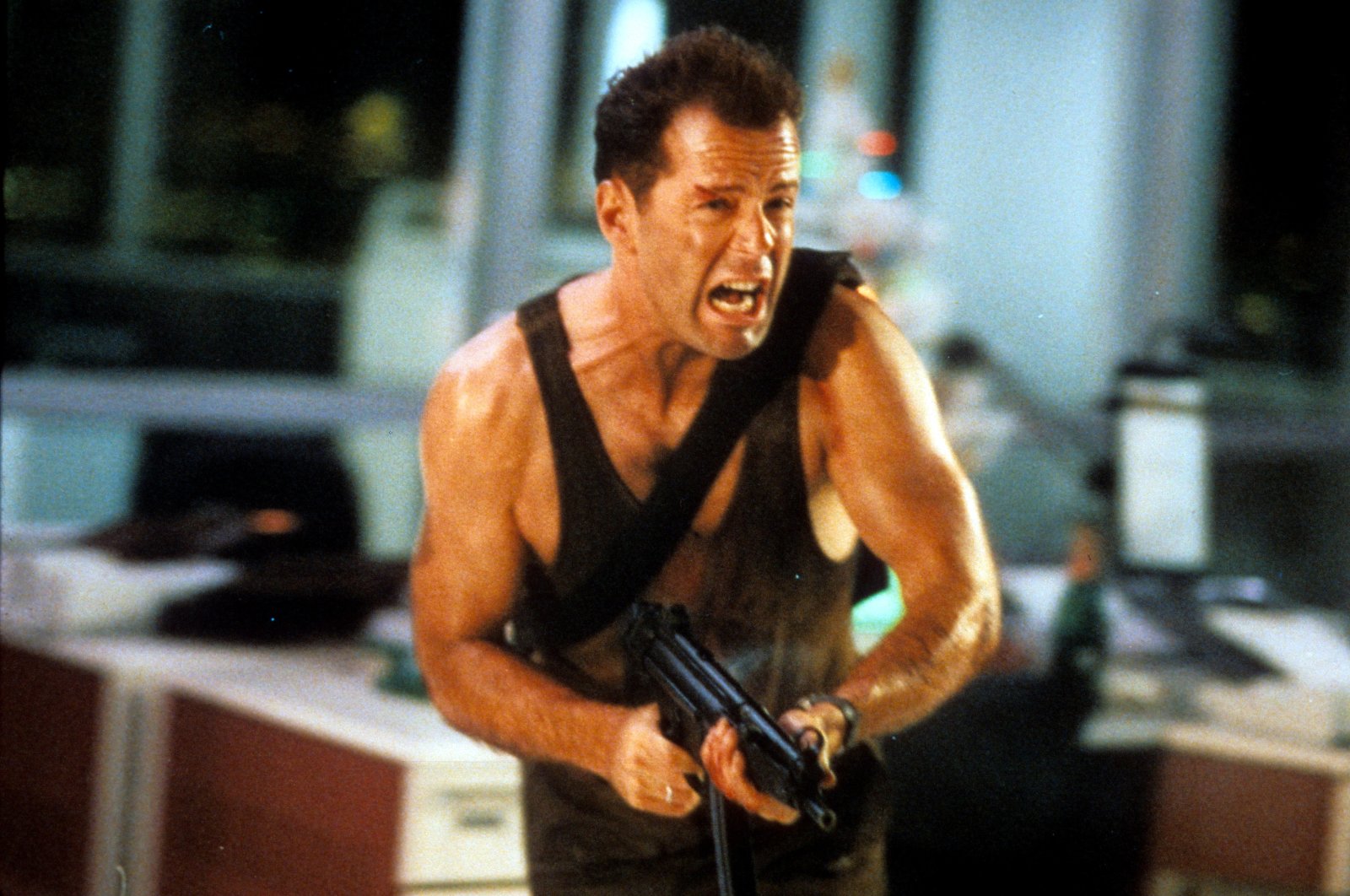 Bruce Willis runs with an automatic weapon in a scene from the film &#039;Die Hard,&#039; 1988. (Getty Images)
