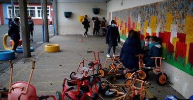 Schoolchildren, wearing protective face masks, play in the courtyard at a private school in Saint-Sebastien-sur-Loire as France is seeing an increase in COVID-19 cases and hospitalizations, Nantes, France, Dec. 10, 2021. (REUTERS Photo)