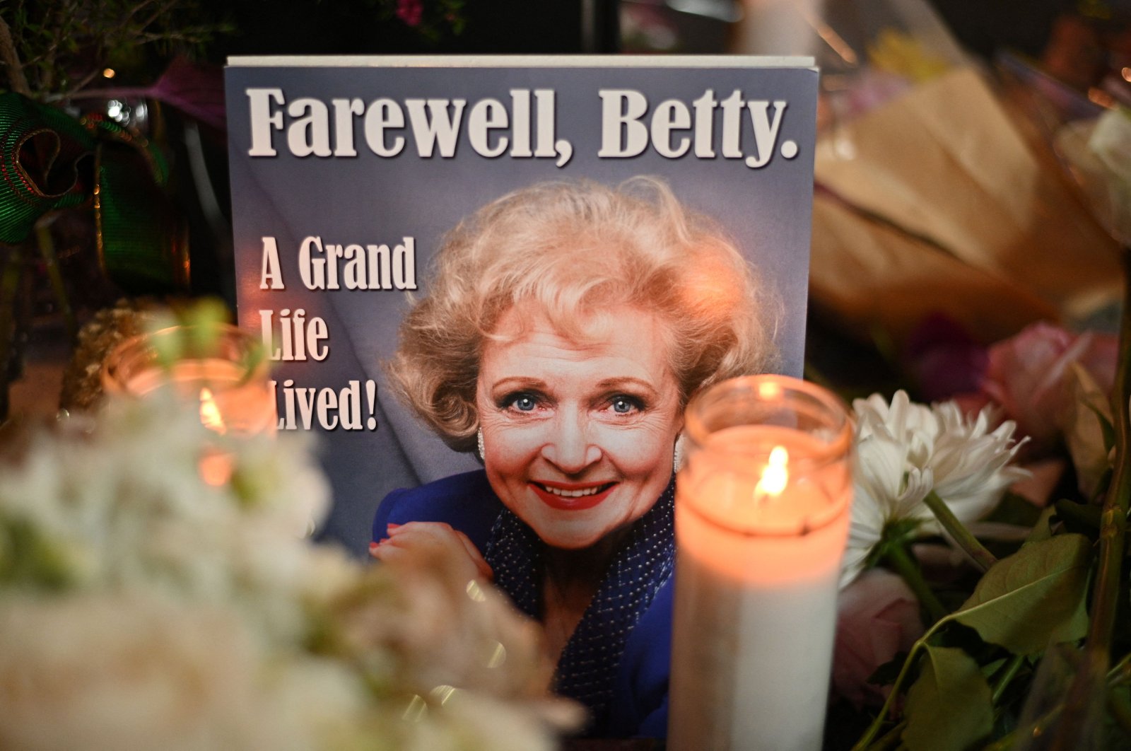 Flowers, candles and mementos cover the star of late actress Betty White on the Hollywood Walk of Fame, in Los Angeles, California, Dec. 31, 2021. (Photo by Robyn Beck / AFP)