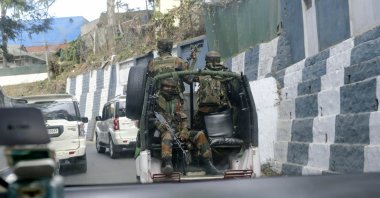 Indian army soldiers ride past the main town in a convoy in Kohima, capital of northeastern Nagaland state, India, Dec. 5, 2021. (AP Photo)