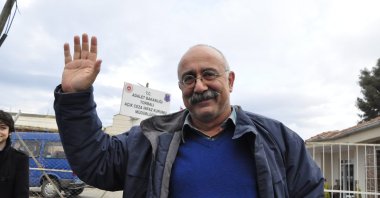 Sevan Nişanyan waves outside the prison before he starts serving his term, in Izmir, western Turkey, Jan. 3, 2014. (DHA PHOTO)