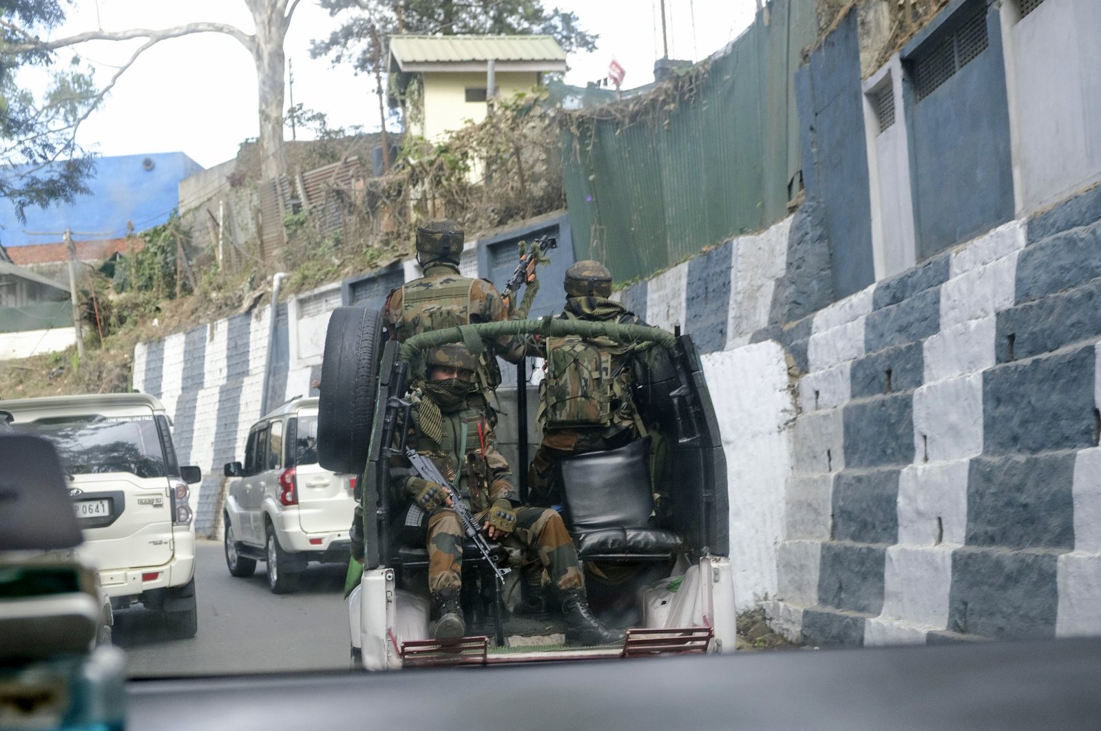 Indian army soldiers ride past the main town in a convoy in Kohima, capital of northeastern Nagaland state, India, Dec. 5, 2021. (AP Photo)