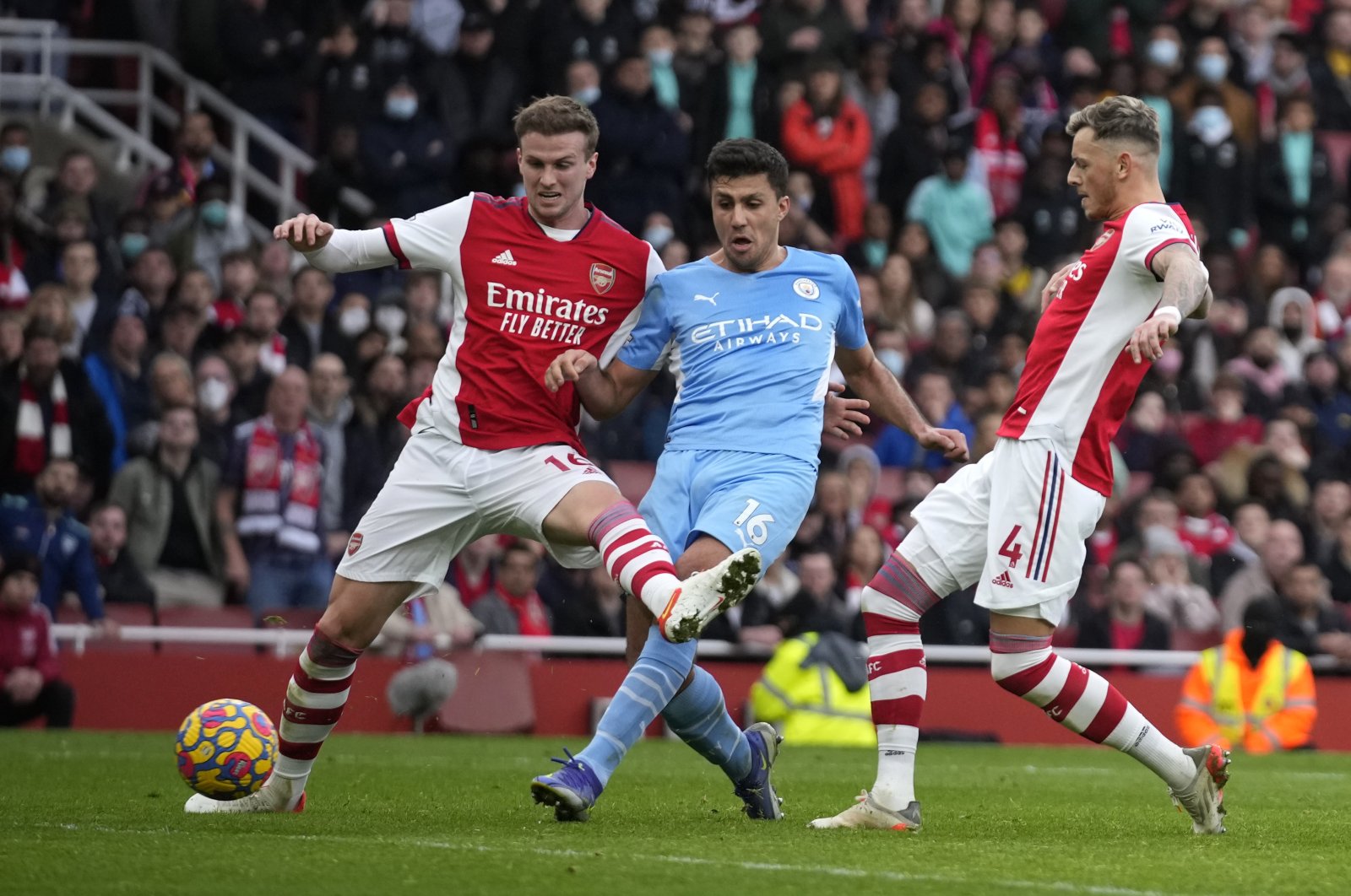 Manchester City&#039;s Rodrigo (C) shoots to score past Arsenal&#039;s Rob Holding (L) and Ben White during a Premier League match at the Emirates Stadium, London, England, Jan. 1, 2022. (AP Photo)
