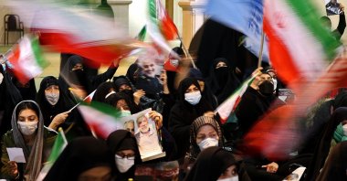 Iranians lift national flags during a ceremony commemorating the second anniversary of the killing in Iraq of top commander Qasem Soleimani (portrait) and Iraqi commander Abu Mahdi al-Muhandis in a U.S. raid, in the capital Tehran, Iran, Jan. 3, 2022. (Photo by ATTA KENARE / AFP)