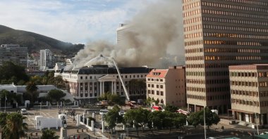 Firefighters work at the parliament as the fire flared up again, in Cape Town, South Africa, Jan. 3, 2022. (REUTERS/Sumaya Hisham)