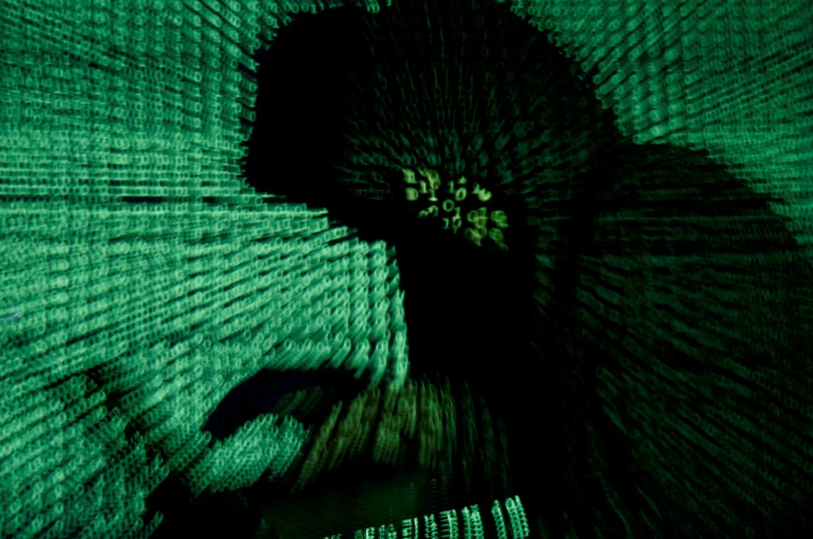 A man holds a laptop as cyber code is projected on him in this illustration picture taken on May 13, 2017. (Reuters Photo)