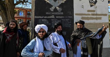 Taliban provincial culture chief Mullah Habibullah Mujahid (R) stands with Taliban members next to a section of a wall of a former U.S. military base with the names of U.S. soldiers, Ghazni, Afghanistan, Nov. 15, 2021. (AFP Photo)