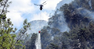 A helicopter drops water on a burning forest, in Muğla, southwestern Turkey, Sept. 8, 2018. (AA PHOTO) 
