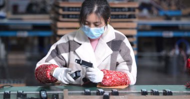 A woman works on an assembly line producing speakers at a factory in Fuyang, in China's eastern Anhui province, Nov. 30, 2021. (Reuters Photo)