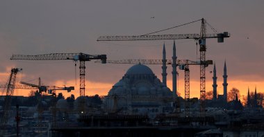 The sun sets behind the cranes of the Galata Port construction site and a mosque in Istanbul, Turkey, Jan. 23, 2020. (Reuters File Photo)