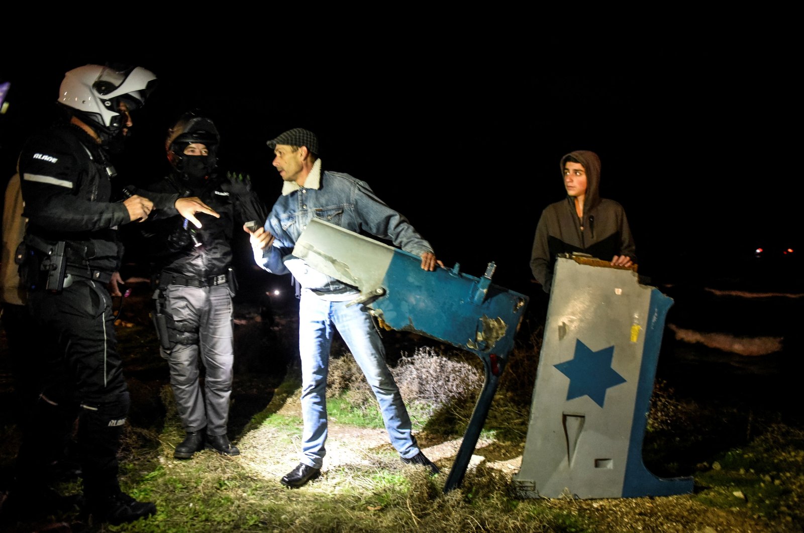 Police speak with Israelis as they hold parts of a military helicopter at the shore after it crashed off the coast of the Mediterranean near Haifa, Israel, Jan. 3, 2022. (Reuters Photo)