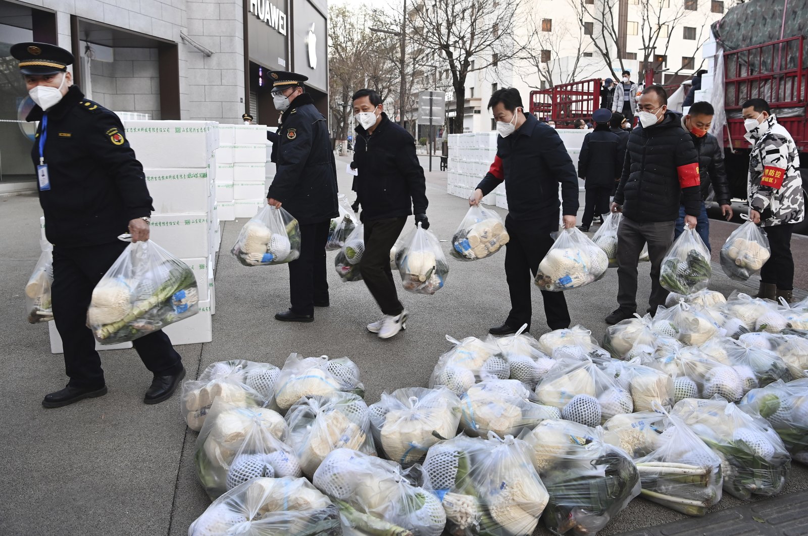 In this photo released by Xinhua News Agency, subdistrict office staff carry daily necessities to be delivered to households under closed-off management in Xi&#039;an, in northwestern China&#039;s Shaanxi Province, Dec. 29, 2021. (AP Photo)