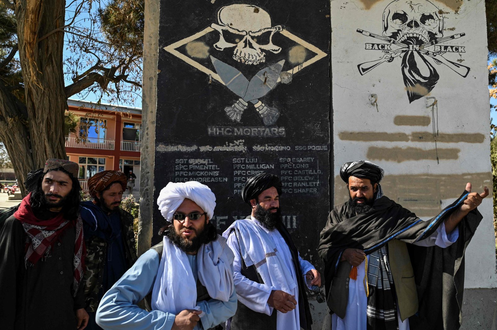 Taliban provincial culture chief Mullah Habibullah Mujahid (R) stands with Taliban members next to a section of a wall of a former U.S. military base with the names of U.S. soldiers, Ghazni, Afghanistan, Nov. 15, 2021. (AFP Photo)