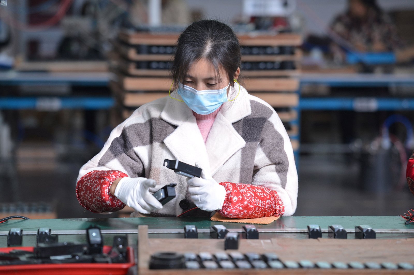 A woman works on an assembly line producing speakers at a factory in Fuyang, in China&#039;s eastern Anhui province, Nov. 30, 2021. (Reuters Photo)