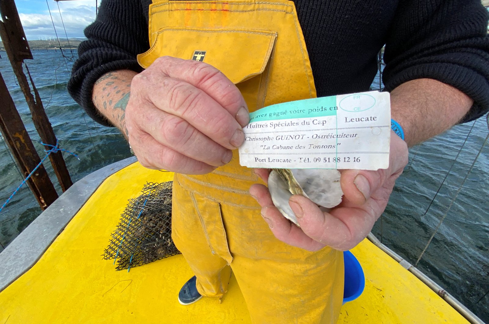 French oyster farmer Christophe Guinot shows a note left in an empty shell to warn customers they are buying from thieves, near Leucate, southern France, Dec. 28, 2021. (Reuters Photo) 